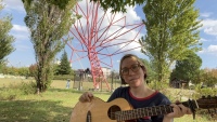 Sitting on tree roots with my guitar.